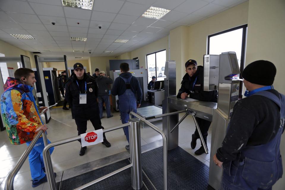 Security guards check visitors at the entrance to the olympic park in Adler near Sochi January 16, 2014. President Vladimir Putin said on Thursday no athlete would face discrimination at next month's Winter Olympics, hoping to ease international concern over a Russian law banning gay "propaganda". REUTERS/Alexander Demianchuk (RUSSIA - Tags: SPORT OLYMPICS POLITICS CRIME LAW)