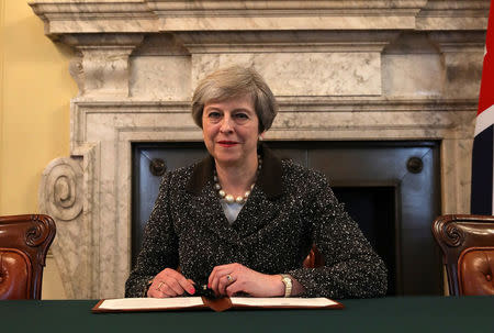 British Prime Minister Theresa May in the cabinet office signs the official letter to European Council President Donald Tusk invoking Article 50 and the United Kingdom's intention to leave the EU on March 28, 2017 in London, England. REUTERS/Christopher Furlong/Pool