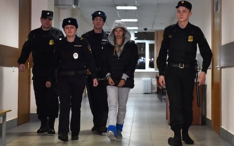 Bailiffs lead Ms Vashukevich into court - Credit: Vasily Maximov/AFP