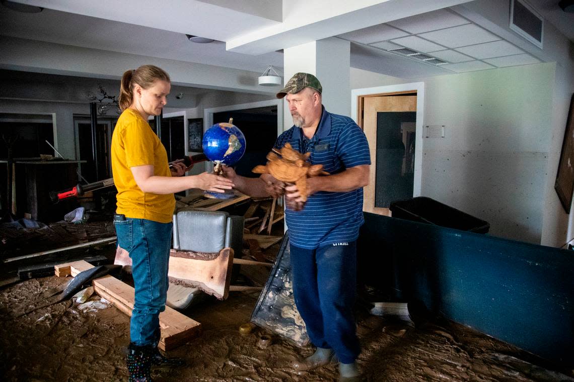 Melissa Helton and her husband Keith Helton salvage objects from her office at the Hindman Settlement School after historic flooding damaged the entire first floor in the building in Hindman, Ky., Saturday, July 30, 2022.