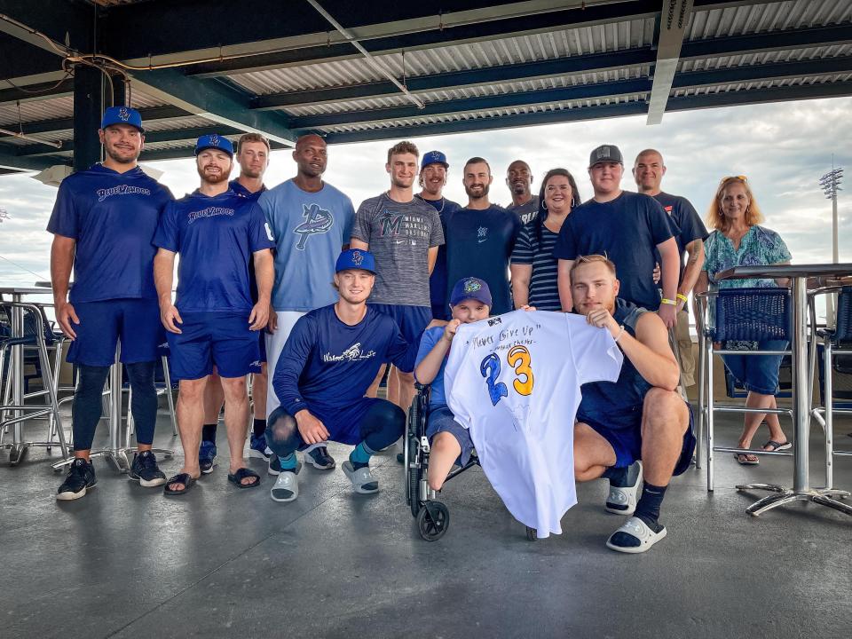 Blue Wahoos pitcher Andrew McInvale (kneeling) with Gunnar Chester, along with other Blue Wahoos teammates. Gunnar's mother Rachel, husband Steve and older brother Micheal are in middle row.