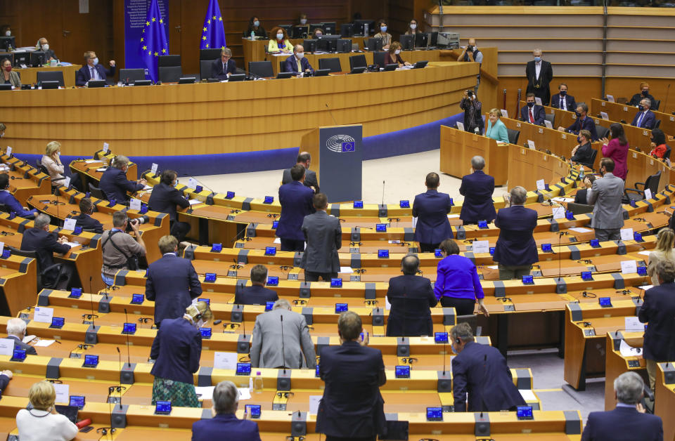 Members of European Parliament stand and applaud after German Chancellor Angela Merkel, right top, addressed the plenary chamber at the European Parliament in Brussels, Wednesday, July 8, 2020. Germany has just taken over the European Union's rotating presidency, and must chaperone the 27-nation bloc through a period of deep crisis for the next six months and try to limit the economic damage inflicted by the coronavirus. (AP Photo/Olivier Matthys)