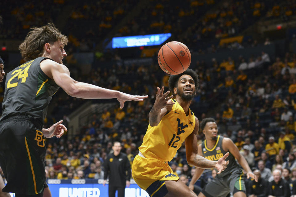 West Virginia guard Taz Sherman (12) and Baylor guard Matthew Mayer (24) vie for a loose ball during the first half of an NCAA college basketball game in Morgantown, W.Va., Tuesday, Jan. 18, 2022. (William Wotring)