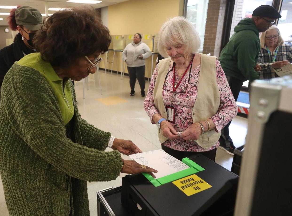 Poll workers Ernestine Hayes and Shirley Dickinson assist voters at the Summit County Board of Elections on Sunday, the last day of early voting before the May 2 primary.