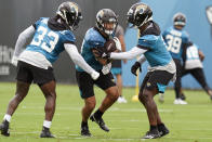 Jacksonville Jaguars running back Nathan Cottrell, center, runs through a drill with running back Dare Ogunbowale (33) and running back Travis Etienne, right, during an NFL football practice, Monday, June 14, 2021, in Jacksonville, Fla. (AP Photo/John Raoux)