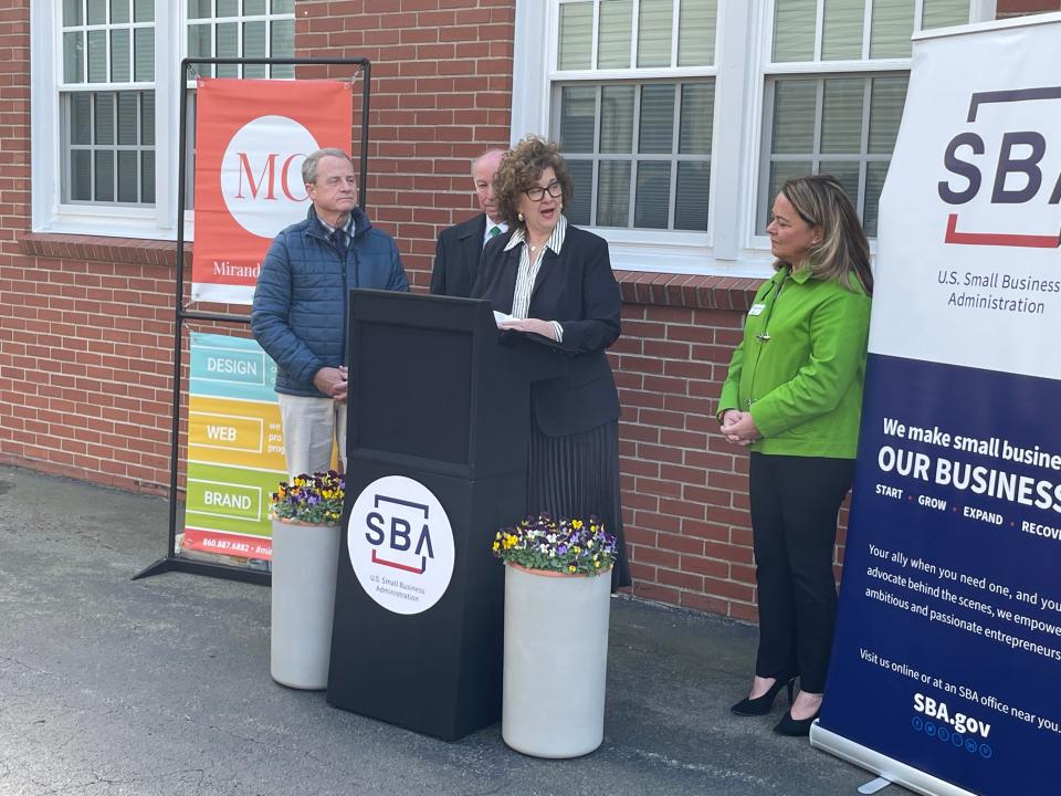 Maria Miranda speaking at the podium beside Norwich Mayor Peter Nystrom, U.S. Rep Joe Courtney and SBA District Director Catherine Marx on Monday. Miranda was named the SBA's Small Business Person of the Year for Connecticut.