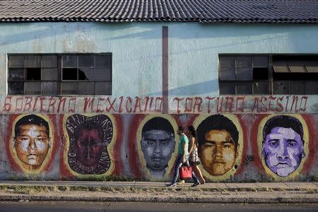 People walk near painting " Ayotzinapa" in honor of 43 mexican missing students in Ayotzinapa, Mexico, for the 12th Havana Biennial, Havana, May 28, 2015. REUTERS/Enrique de la Osa