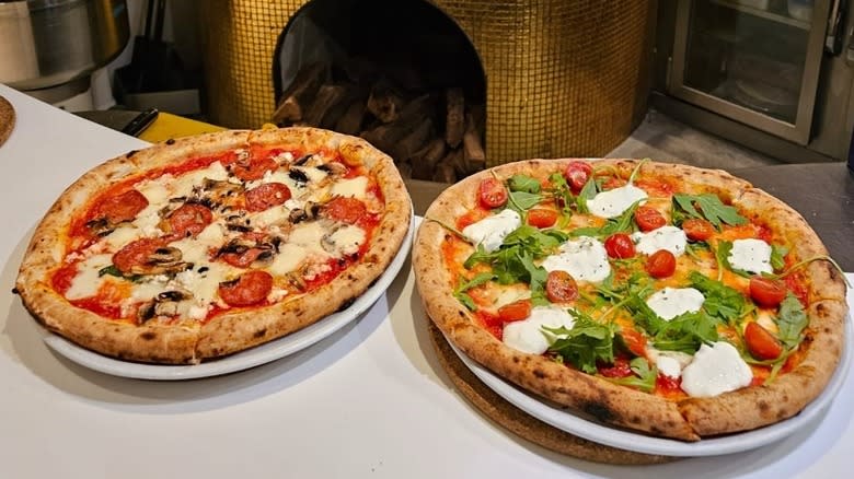 Two pizzas and a gold oven