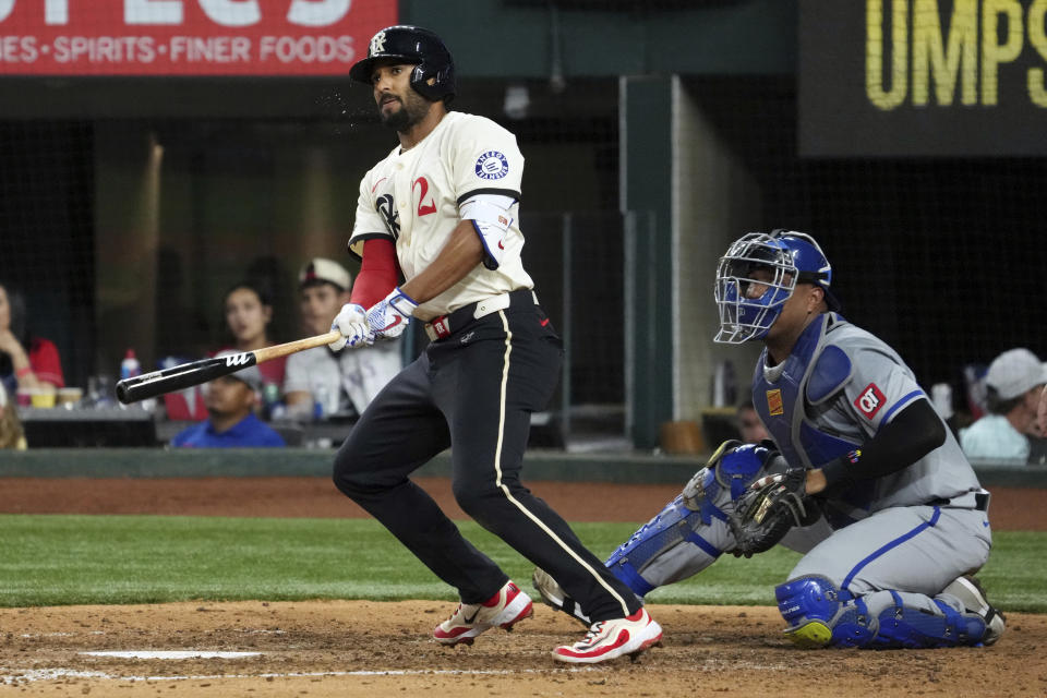 Texas Rangers' Marcus Semien watches his three-run double off Kansas City Royals relief pitcher Sam Long, next to catcher Salvador Perez during the sixth inning of a baseball game Friday, June 21, 2024, in Arlington, Texas. Semien was thrown out trying to advance to third. (AP Photo/Jeffrey McWhorter)