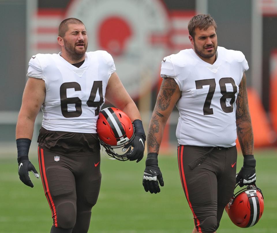 Cleveland Browns center JC Tretter (64) and Cleveland Browns offensive tackle Jack Conklin (78) take the field before NFL football practice, Tuesday, Aug. 10, 2021, in Berea, Ohio. [Jeff Lange/Beacon Journal]