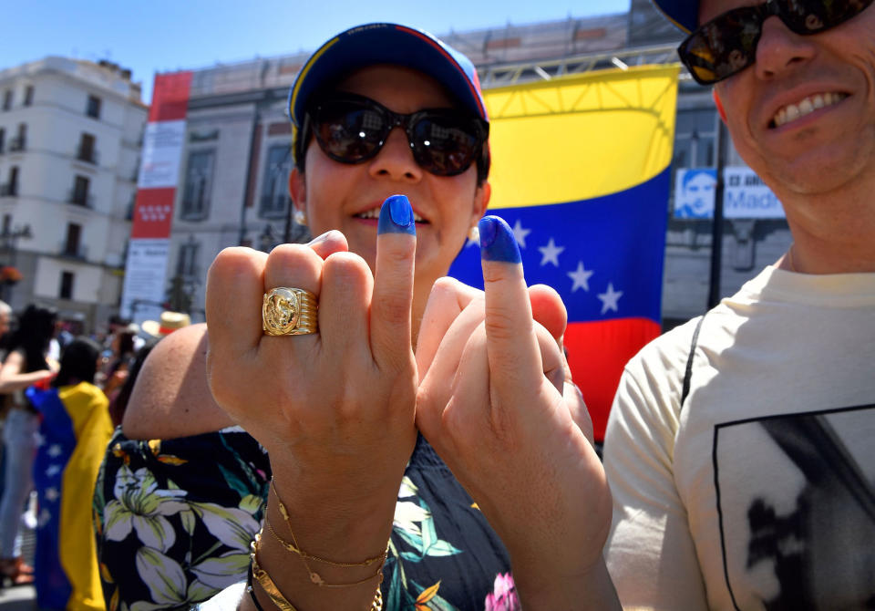 <p>Two Venezuelan residents in Madrid, show their little fingers stained with ink after voting during a symbolic plebiscite on president Maduro’s project of a future constituent assembly, called by the Venezuelan opposition and held at the Puerta del Sol in Madrid on July 16, 2017. (Gerard Julien/AFP/Getty Images) </p>