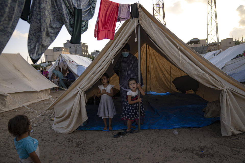 FILE - Palestinian children displaced by the Israeli bombardment of the Gaza Strip stan in a UNDP-provided tent camp in Khan Younis on Thursday, Oct. 19, 2023. Hundreds of Palestinians have crowded into a squalid tent camp in southern Gaza, an image that has brought back memories of their greatest trauma. The impromptu construction of the tent city in Khan Younis to shelter scores of Palestinians who lost or fled their homes during the past days of intense Israeli bombardment has elicited anger, disbelief and sorrow across the Arab world. (AP Photo/Fatima Shbair, File)