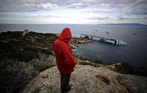 An Isola del Giglio citizen looks at the Costa Concordia. Costa Crociere, the owner of the luxury liner that ran aground off the coast of Italy, killing at least five people, said on Sunday its captain had made "errors of judgment"