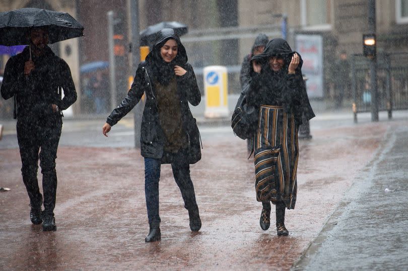 People walking in the rain in the city centre -Credit:PA