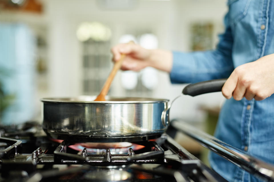 A person cooking with a gas stove