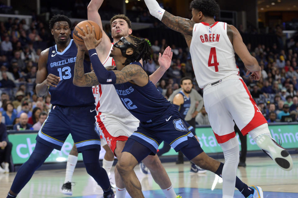 Memphis Grizzlies guard Ja Morant (12) shoots between Houston Rockets guard Jalen Green (4) and center Alperen Sengun as Grizzlies forward Jaren Jackson Jr. (13) moves for position in the second half of an NBA basketball game Wednesday, March 22, 2023, in Memphis, Tenn. (AP Photo/Brandon Dill)