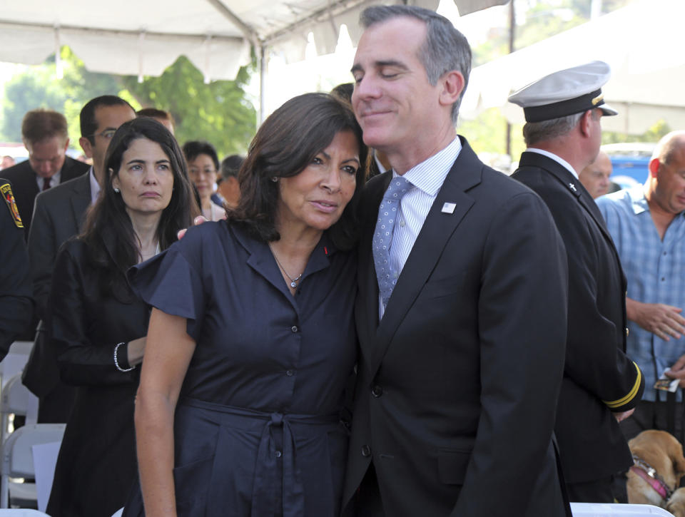 Paris Mayor Anne Hidalgo and Los Angeles Mayor Eric Garcetti share a moment following a ceremony marking the 17th anniversary of the Sept. 11, 2001 terrorist attacks on America, at the Los Angeles Fire Department's training center Tuesday, Sept. 11, 2018. Americans looked back on 9/11 Tuesday with tears and somber tributes. Victims' relatives said prayers for their country, pleaded for national unity and pressed officials not to use the 2001 terror attacks as a political tool in a polarized nation. (AP Photo/Reed Saxon)