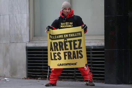 A Greenpeace activist holds a placard which reads, "Stop the Expense" outside France's state-owned electricity company EDF headquarters to protest against nuclear energy safety in Paris, France, December 14, 2016. REUTERS/Jacky Naegelen