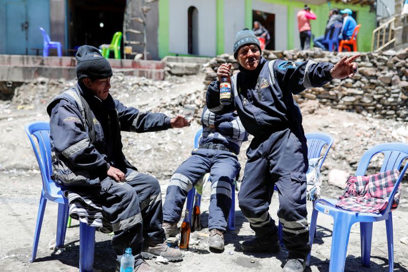 Artisanal gold miners drink beer on a street in La Rinconada, in the Andes