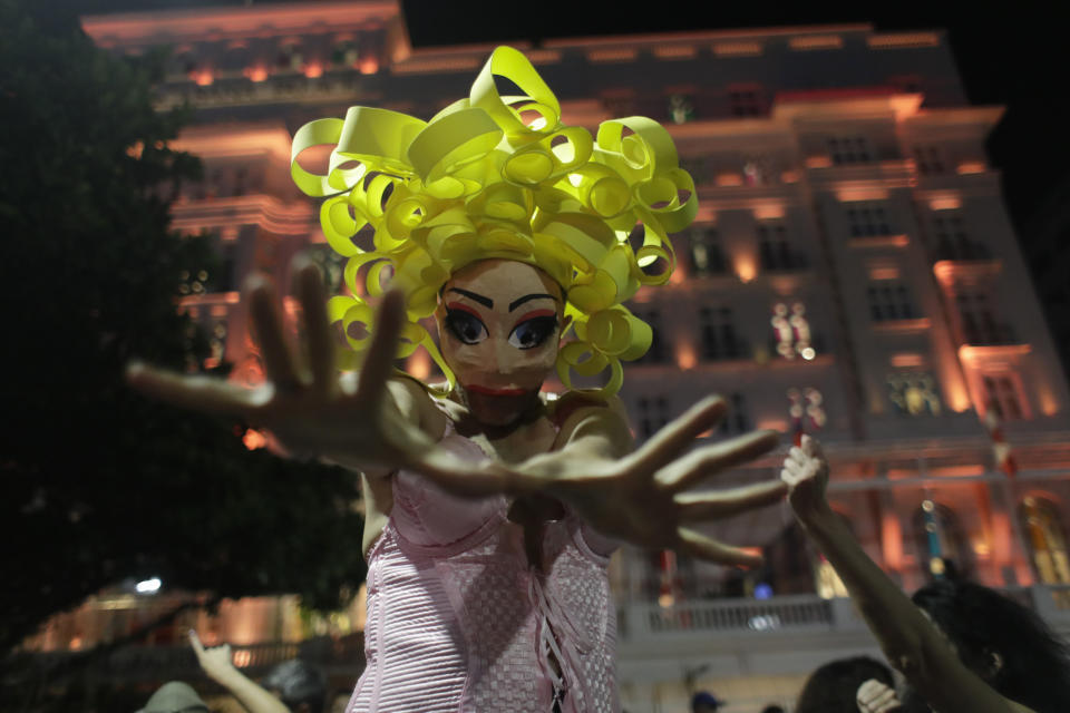 A fan of Madonna, wearing a mask, strikes a pose during a rehearsal for Madonna's The Celebration Tour, in Rio de Janeiro, Brazil, Thursday, May 2, 2024. Madonna will conclude her tour on Saturday with a free concert at Copacabana Beach. (AP Photo/Bruna Prado)