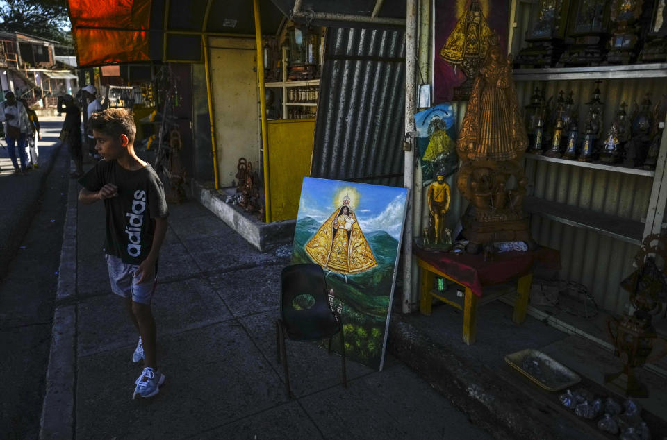 Paintings and statues of the Virgin of Charity of El Cobre stand for sale outside the shrine of the Cuban patron saint in El Cobre, Cuba, Sunday, Feb. 11, 2024. The Vatican-recognized Virgin, venerated by Catholics and followers of Afro-Cuban Santeria traditions, is at the heart of Cuban identity, uniting compatriots from the Communist-run Caribbean island to those who were exiled or emigrated to the U.S. (AP Photo/Ramon Espinosa)