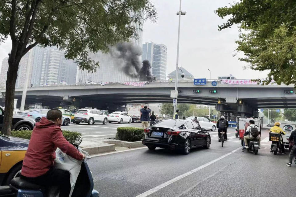 Smoke rises from the Sitong bridge in Beijing during anti-government protests on Oct. 13, 2022.