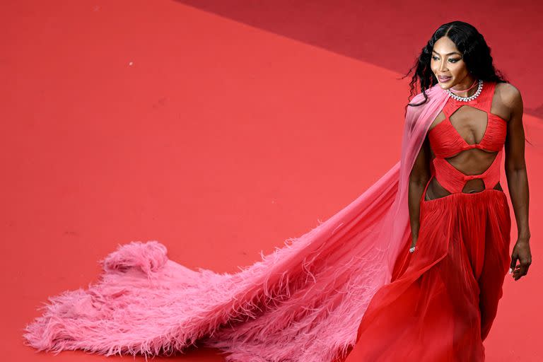 La mítica modelo británica Naomi Campbell acaparó todas las miradas con un glamoroso vestido rojo con larga capa rosada