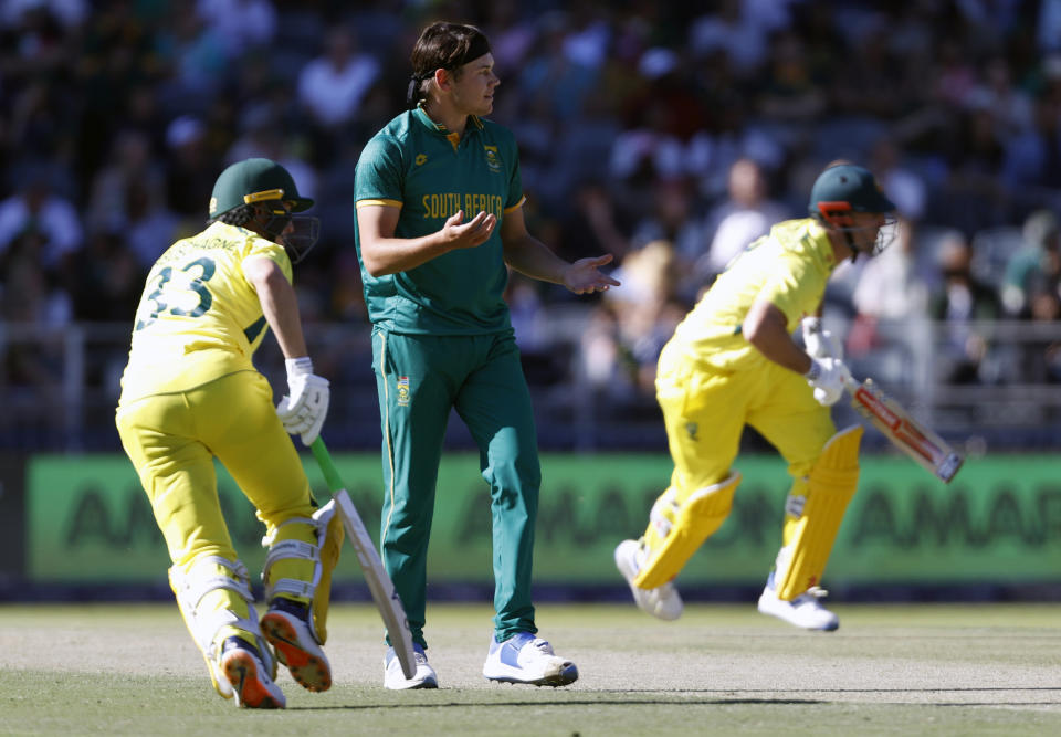 South Africa's Gerald Coetzee, centre, reacts while Australia's Marnus Labuschagne and Mitchell Marsh make a run during the fifth and final ODI cricket match between South Africa and Australia at the Wanderers Stadium in Johannesburg, South Africa, Sunday, Sept. 17, 2023. (AP Photo)