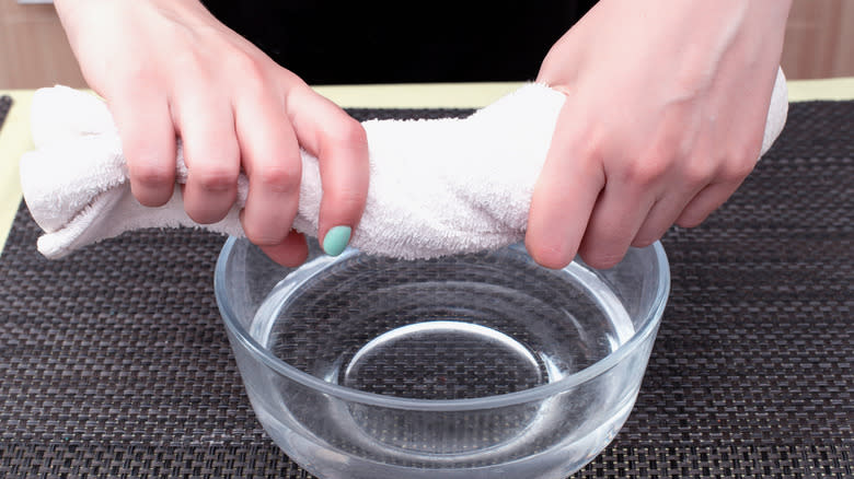 dish towel being wrung out over bowl