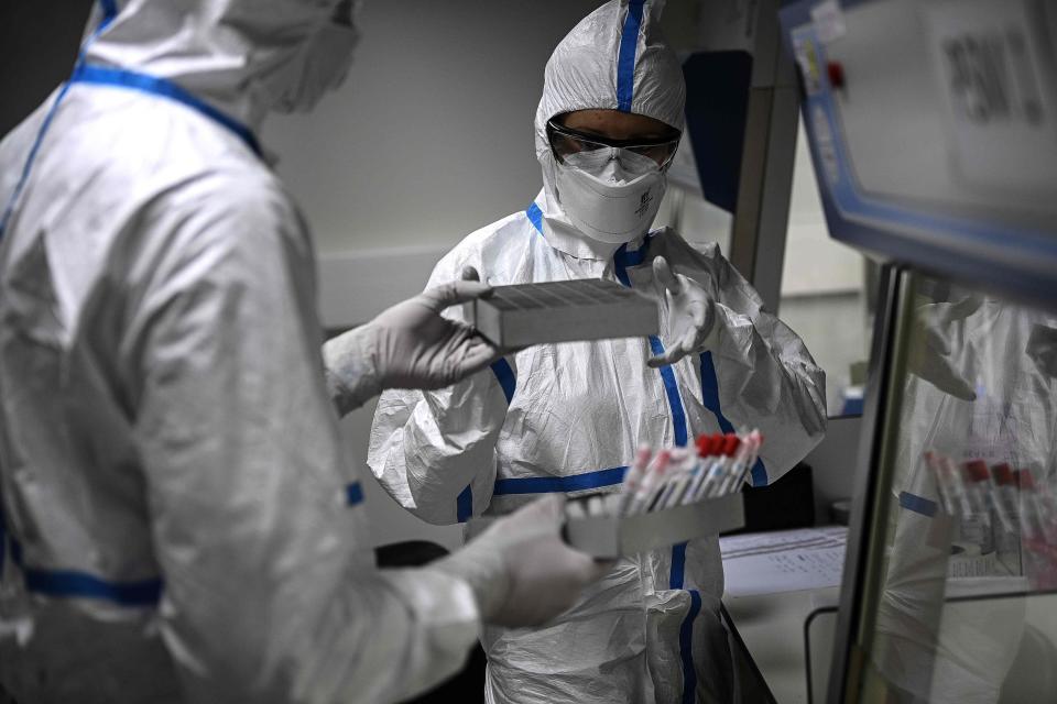 Laboratory technicians wearing protective equipment work on the genome sequencing of the SARS-CoV-2 virus, which causes COVID-19, and its variants at the National Reference Center for Respiratory Infection Virus at the Pasteur Institute in Paris on Jan. 21, 2021.