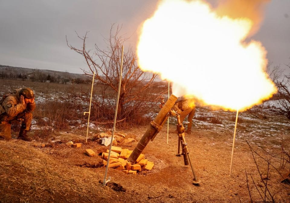 Ukrainian servicemen fire a mortar toward Russian positions (via REUTERS)