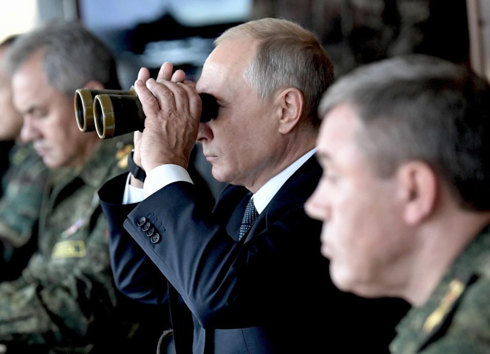 FILE - Russian President Vladimir Putin looks through a binocular as Russian Defense Minister Sergei Shoigu, left, and the Head of the General Staff of the Armed Forces of Russia and First Deputy Defense Minister Valery Gerasimov, right, sit near him during a military exercising at the training ground "Telemba", about 80 kilometers (50 miles ) north of the city of Chita during the military exercises Vostok 2018 in Eastern Siberia, Russia, on Sept. 13, 2018. Russia's military defeats in Ukraine along with the tensions fueled by an ill-planned mobilization and open rifts among the Kremlin insiders have left Putin increasingly cornered. (Alexei Nikolsky, Sputnik, Kremlin Pool Photo via AP, File)