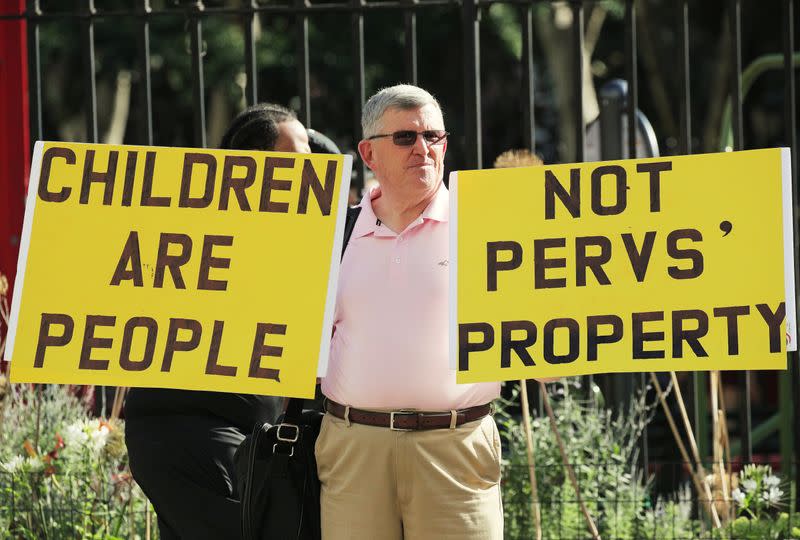 FILE PHOTO: A protester holds up signs outside the courthouse ahead of a bail hearing in U.S. financier Jeffrey Epstein's sex trafficking case in New York City