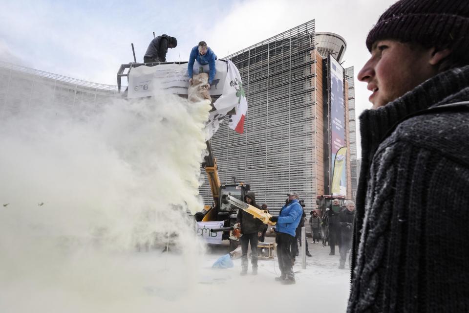 European dairy farmers spray the EU Council building with milk powder to protest the crisis in their sector, in Brussels on Monday, Jan. 23, 2017. The sector has been hit with sagging prices and production costs squeezing profits to the extent that has driven many farmers to the brink of bankruptcy. The EU's executive Commission has approved some support measures over the past year, but the farmers fear that releasing more milk powder on the market would further complicate their plight. (AP Photo/Geert Vanden Wijngaert)