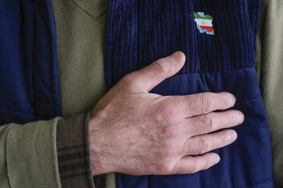 An Iranian business owner holds his hand to his chest decorated with the the historic Lion and Sun flag, as he greets customers in the so-called "Tehrangeles" neighborhood in the Westwood district of Los Angeles on Monday, May 20, 2024. (AP Photo/Damian Dovarganes)