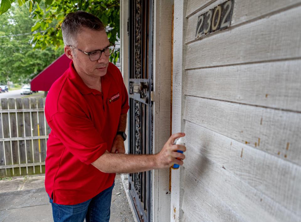 Dr. Brian Guinn, assistant professor of epidemiology at the University of Louisville School of Public Health, applies a lead testing solution to the exterior of this house on W. Kentucky Street in Louisville's California neighborhood. Aug. 1, 2023.