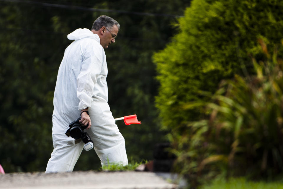 An investigator works the scene of a small plane crash in a residential neighborhood in Upper Moreland, Pa., Thursday, Aug. 8, 2019. Upper Moreland Police Chief Michael Murphy says the plane hit several trees before it finally came to rest. He said everyone aboard the plane was killed. (AP Photo/Matt Rourke)