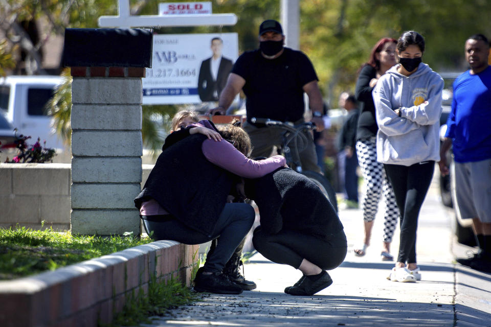 Grieving family members comfort one another after a nearby fireworks stash exploded in Ontario, Calif., Tuesday, March 16, 2021. (Watchara Phomicinda/The Orange County Register via AP)