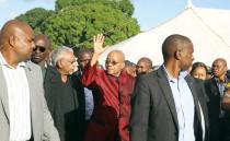 Foreign nationals shout out in displeasure as South African President Jacob Zuma waves in a temporary refugee camp in Chatsworth, south of Durban on April 18, 2015 during his visit marked by the hostile reaction of foreign nationals