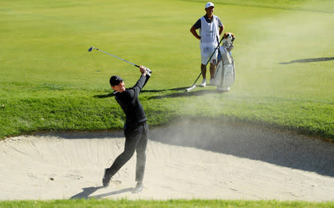 Rory McIlroy hits out of a bunker - Credit: Getty images