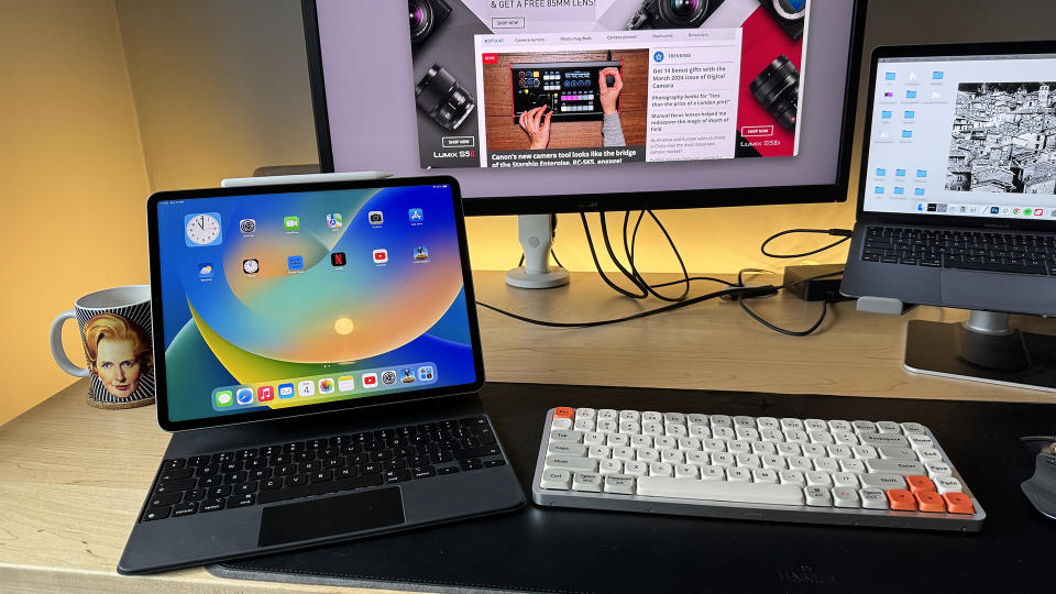 The iPad Pro 2022 on a desktop, next to a monitor, keyboard and a MacBook Air.