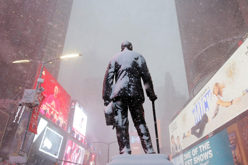 A statue of American composer, playwright, actor, and producer George M. Cohan stands in Times Square as snow falls in Manhattan