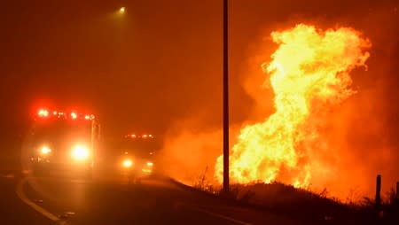 Firefighters battle a wind-driven wildfire in Sylmar, California