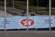 Workers fix a banner with a Hong Kong logo on the National Security Education Day at a police school in Hong Kong Thursday, April 15, 2021. Beijing's top official in Hong Kong on Thursday warned foreign forces not to interfere with the "bottom line" of national security in Hong Kong, threatening retaliation even amid ongoing tensions between China and Western powers. (AP Photo/Vincent Yu)