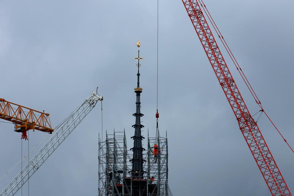 Scaffolding is being removed around the spire of Notre Dame de Paris cathedral, showing the rooster and the cross on Monday in Paris. Notre Dame is expected to reopen in December following the devastating fire in April 2019.