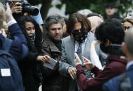 Actor Johnny Depp, centre, is surrounded by fans as he arrives at the High Court in London, Thursday, July 16, 2020. Depp is suing News Group Newspapers, publisher of The Sun, and the paper’s executive editor, Dan Wootton, over an April 2018 article that called him a “wife-beater.” The Sun’s defense relies on a total of 14 allegations by his ex-wife Amber Heard of Depp’s violence. He strongly denies all of them. (AP Photo/Alastair Grant)