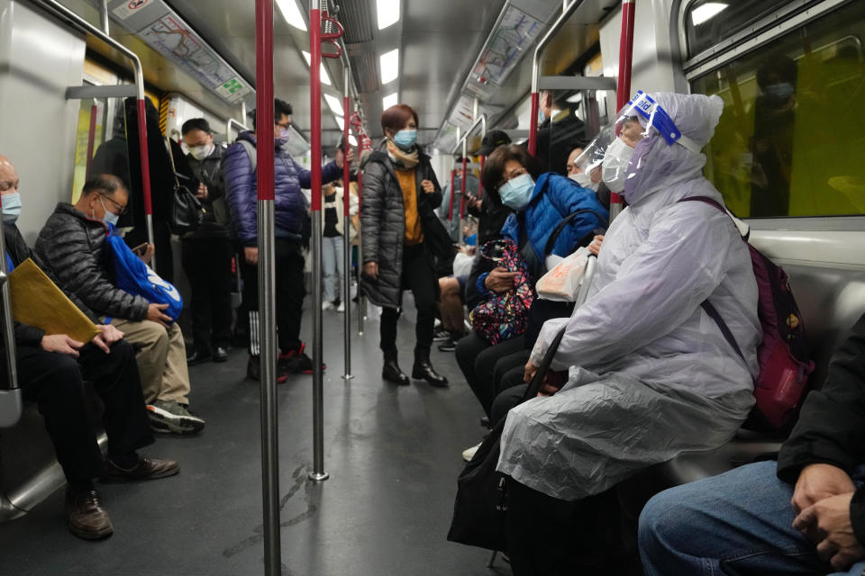 FILE - A woman wearing a face mask and face shield, sits in a train in Hong Kong, Wednesday, Feb. 23, 2022. The World Health Organization downgraded its assessment of the coronavirus pandemic on Friday, May 5, 2023, saying it no longer qualifies as a global emergency. (AP Photo/Kin Cheung, File)