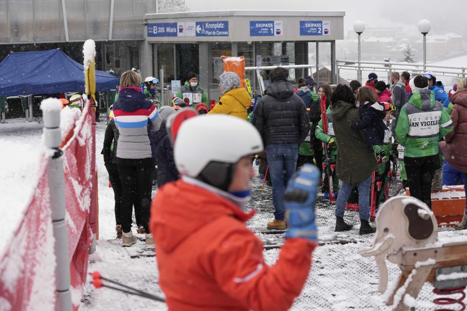 People wait at the ticket office in San Vigilio di Marebbe, Italy South Tyrol, Saturday, Nov. 27, 2021. After nearly two years of being restricted to watching snow accumulate on distant mountains, Italian skiers are finally returning to the slopes that have been off limits since the first pandemic lockdown in March 2020. But just as the industry is poised to recover from a lost 2020-2021 season after an abrupt closure the previous year, a spike in cases in the Alpine province bordering Austria is underlining just how precarious the situation remains. (AP Photo/Luca Bruno)