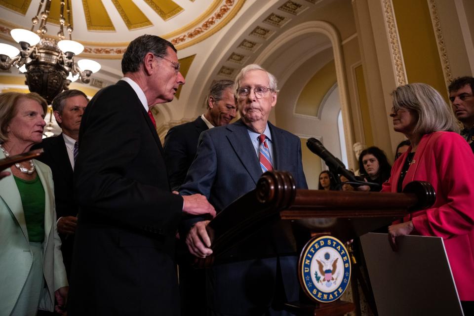 July 26, 2023: (L-R) Sen. John Barrasso (R-WY) reaches out to help Senate Minority Leader Mitch McConnell (R-KY) after McConnell froze and stopped talking at the microphones during a news conference after a lunch meeting with Senate Republicans U.S. Capitol in Washington, DC. Also pictured, L-R, Sen. Shelley Moore Capito (R-WV), Sen. Steve Daines (R-MT), Sen. John Thune (R-SD), and Sen. Joni Ernst (R-IA). McConnell was escorted back to his office and later returned to the news conference and answered questions.