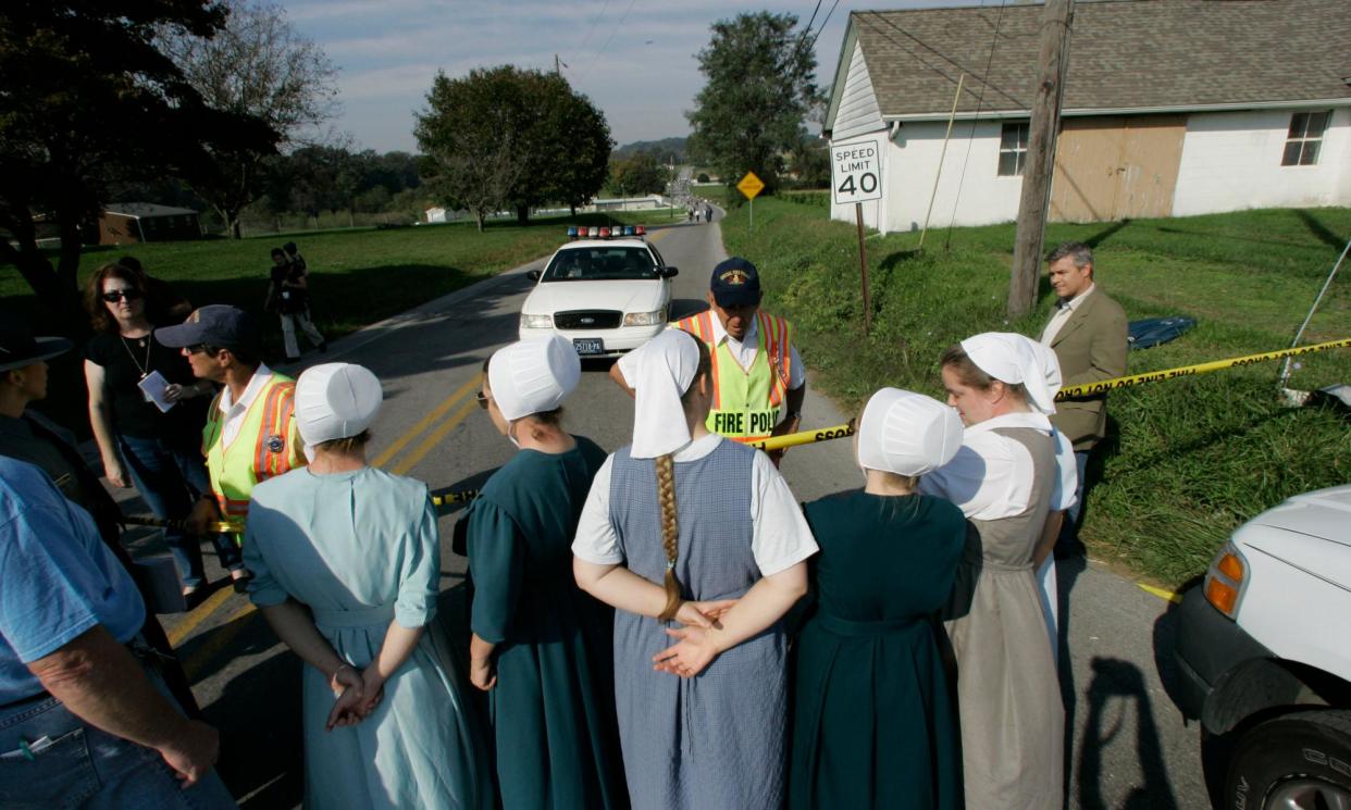 <span>A group of women talk to officials at a police line in Nickel Mines, Pennsylvania, after the shooting on 4 October 2006.</span><span>Photograph: Mary Altaffer/AP</span>